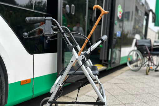 eine Gehhilfe steht an einem grün-weißen Bus