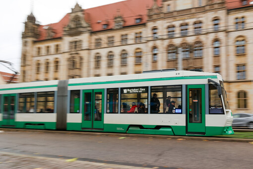 Eine Straßenbahn der Linie 10 der Magdeburger Verkehrsbetrieb fährt über den Breiten Weg in Richtung Norden.