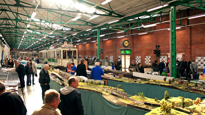 Menschen sehen sich eine Modelleisenbahn in der Wagenhalle des Museumsdepots Sudenburg an.