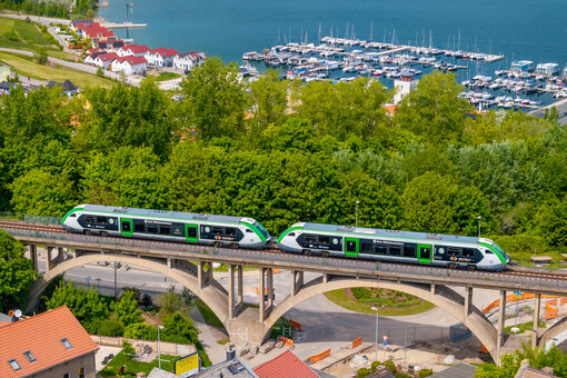 Ein grünweißer Zug des Typs Alstom Coradia von DB Regio im Mein-Takt-Design fährt in Doppeltraktion über das Müchelner Viadukt