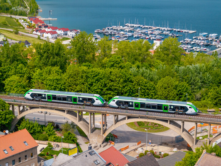 Ein grünweißer Zug des Typs Alstom Coradia von DB Regio im Mein-Takt-Design fährt in Doppeltraktion über das Müchelner Viadukt