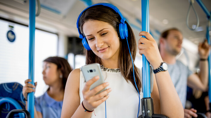 stehende junge Frau im Bus